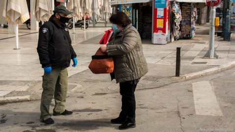Woman has her movement papers checked in Athens, Greece
