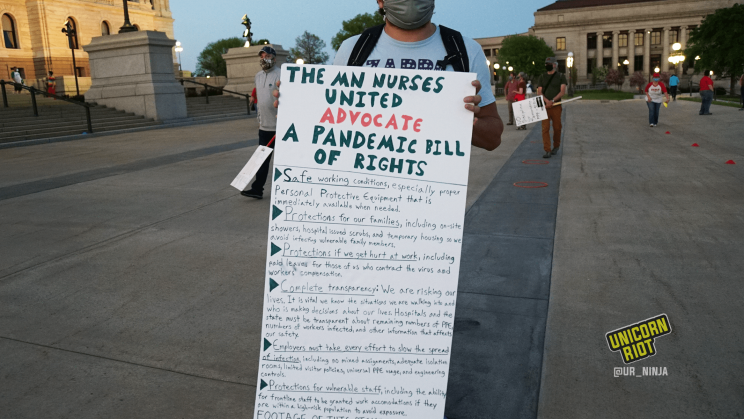 image: a protester holds a handmade long sign, "The MN Nurses United Advocate a Pandemic Bill of Rights" listing the first six points on the document.