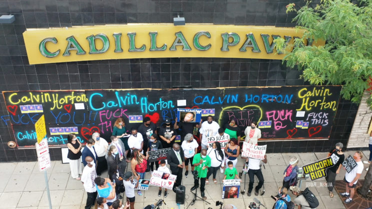 Attorney Ben Crump leads a press conference in front of Cadillac Pawn, where Calvin Horton was killed