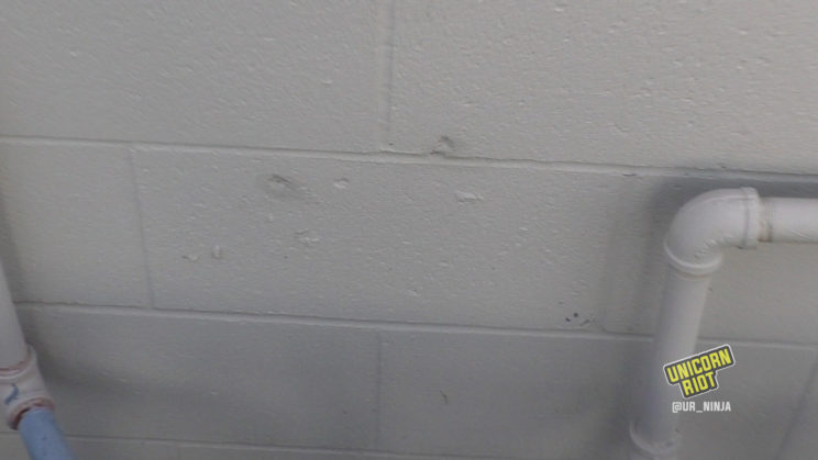 divuts in the wall show where bullets hit the building