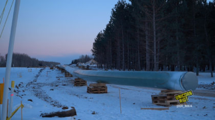 Line 3 Pipeline lifted off the snowy ground by wooden pallets at dusk