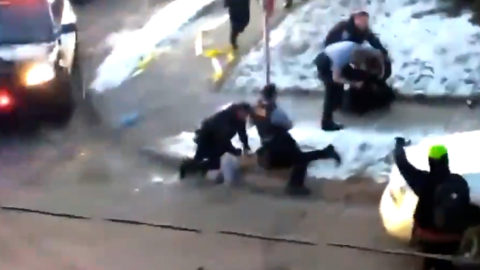minneapolis police kneeling on a person's neck while they hang off the curb with their face into the concrete